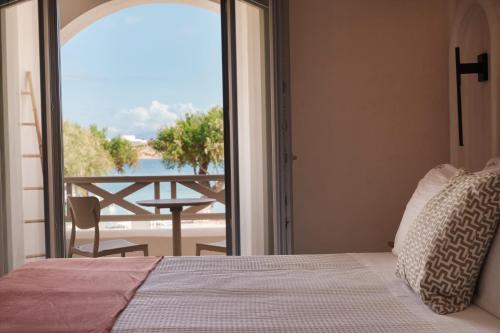 a bedroom with a bed and a view of the ocean at Salt Suites Paros in Naousa