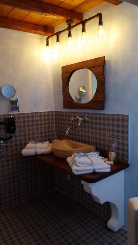 a bathroom with a sink and a tub and a mirror at Manolia in Hydra