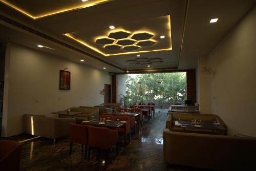 a dining room with tables and chairs and a window at Vinn Amar Vilas by Vesta in Bharatpur