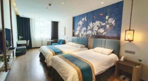 a hotel room with two beds and a painting on the wall at Magnotel Shenyang Consulate Qingnian Street in Shenyang
