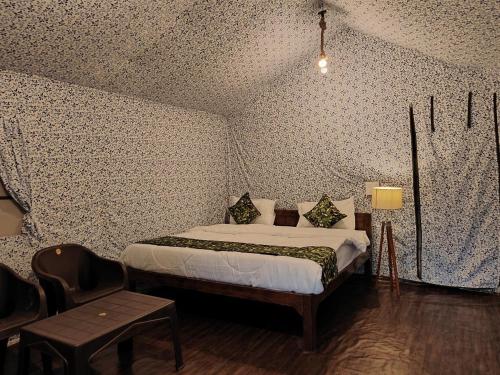 een slaapkamer met een bed in een kamer met behang bij the jungle book - luxury camps by lake & woods in Bhīm Tāl