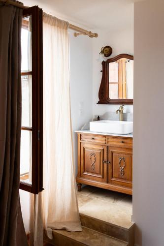 a bathroom with a sink and a mirror at L'Auberge des Clés in Chevannes