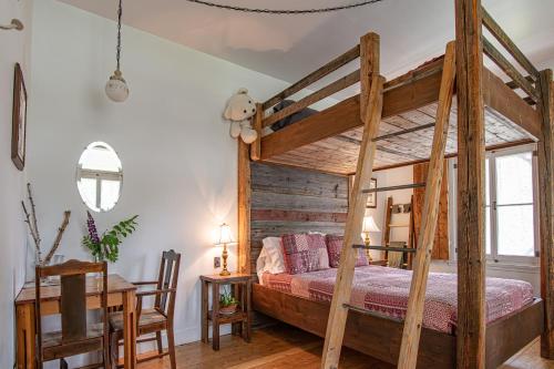 a bedroom with a wooden bunk bed and a table at Auberge Carpe Diem in Baie-Saint-Paul