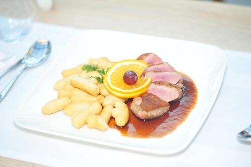 a plate of food with meat and vegetables on a table at Thermal Hotel Balance Lenti in Lenti