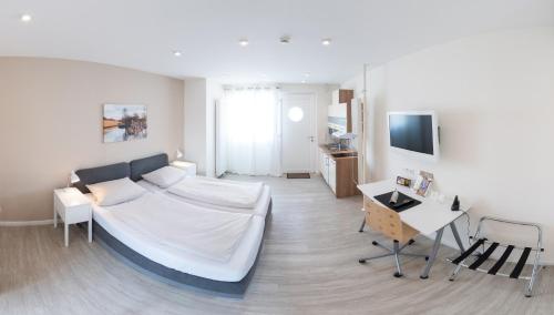 a living room with a white bed and a table at Schäfers Hotel, Self-Check-in, Cafe und Bäcker am Hotel in Vechta