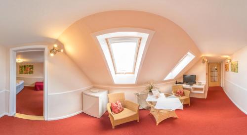 a room with an attic with a table and chairs at Schäfers Hotel, Self-Check-in, Cafe und Bäcker am Hotel in Vechta
