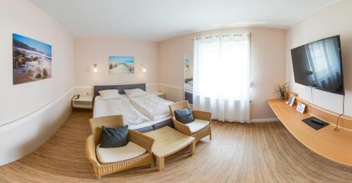 a hotel room with a bed and two chairs at Schäfers Hotel, Self-Check-in, Cafe und Bäcker am Hotel in Vechta