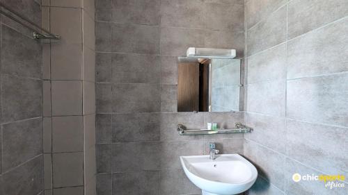 ein Badezimmer mit Waschbecken, Spiegel und Toilette in der Unterkunft Chic studio with parking and pool in Douala