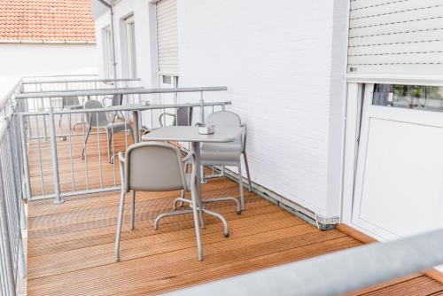a row of tables and chairs on a balcony at Schäfers Hotel, Self-Check-in, Cafe und Bäcker am Hotel in Vechta