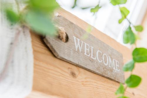 a welcome sign on the side of a building at Schäfers Hotel, Self-Check-in, Cafe und Bäcker am Hotel in Vechta