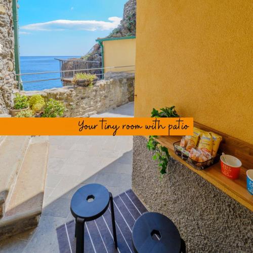 a view of the ocean from a balcony with two stools at Ventu de Ma Studios & Rooms in Vernazza