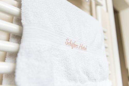 a white towel hanging on a white staircase at Schäfers Hotel, Self-Check-in, Cafe und Bäcker am Hotel in Vechta