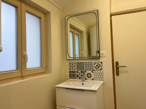 une salle de bains avec un lavabo et un miroir dans l'établissement Le Terracotta, central et intimiste, à La Celle-sous-Gouzon