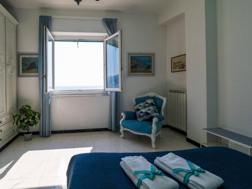 a bedroom with a bed and a chair and a window at Giaella Sea View Apartment in Monterosso al Mare