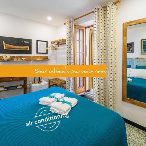 a bedroom with a blue bed and a mirror at Ventu de Ma Studios & Rooms in Vernazza