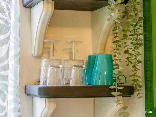 een plank met glazen potten en een plant erop bij Carmelina Tiny Village Room in Vernazza