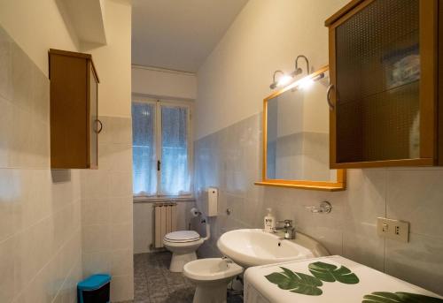een witte badkamer met een wastafel en een toilet bij La Casa di Frida Family Apartment in Vernazza
