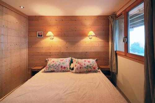 a bedroom with a bed with two pillows and a window at Gîte Les Neufs Lieux in Gérardmer