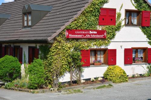 a building with red shutters and a sign on it at Alte Schreinerei-Auberge Harlekin in Singen