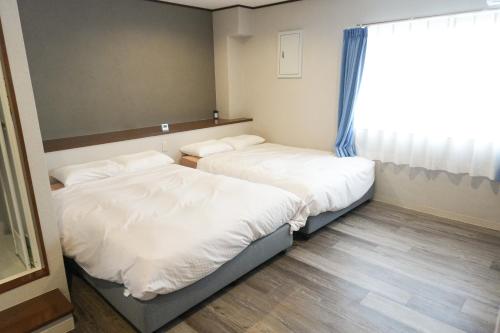 Postel nebo postele na pokoji v ubytování 還元ホテル 名護東江