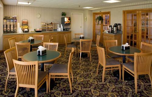 a restaurant with tables and chairs and a kitchen at Luxe Studios Nashville Opryland in Nashville