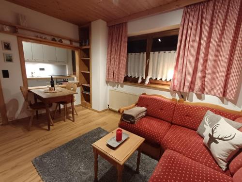 een woonkamer met een rode bank en een tafel bij Ferienwohnung Schösserhof in Reith bei Kitzbühel