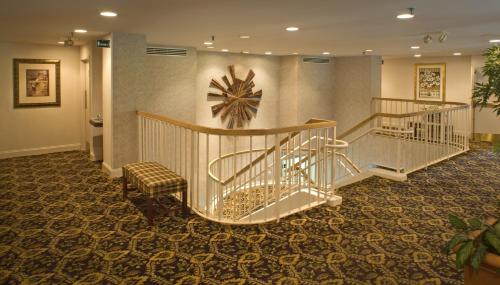 a lobby with stairs and a clock on the wall at Luxe Studios Nashville Opryland in Nashville