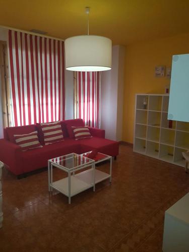 a living room with a red couch and a coffee table at Nest Style Granada in Granada