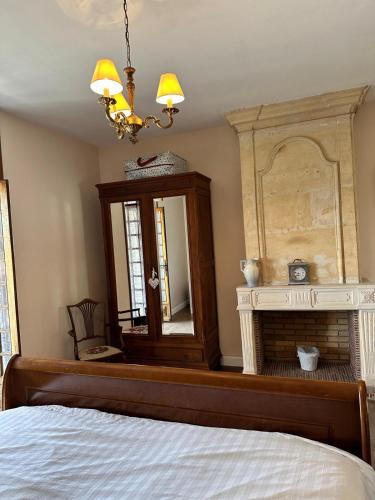 a bedroom with a bed with a mirror and a dresser at Maison De Lafenestre in Saint-Maigrin