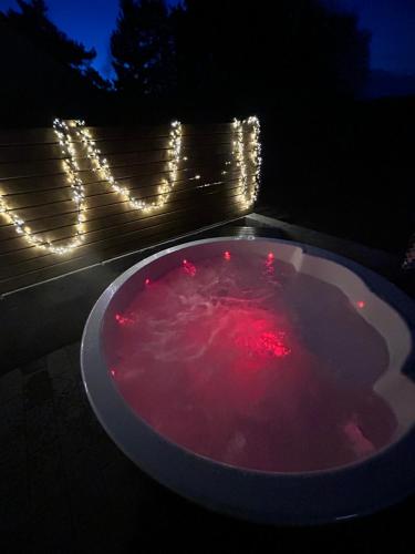 een badkuip gevuld met rode vloeistof met lampjes bij Traumnest Eifel mit Sauna & Whirlpool in Monschau