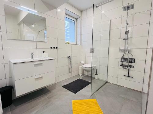 een badkamer met douche, wastafel en toilet bij Jan Gustav Apartments in Liptovský Mikuláš