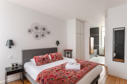 ein Schlafzimmer mit einem großen weißen Bett mit roten Kissen in der Unterkunft Le Rock Fish - Quelques minutes de la plage in Dinard