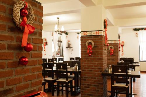 un ristorante con un muro di mattoni e tavoli con decorazioni natalizie di Nomad by Hora cu Brazi a Zărneşti