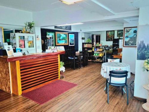 ein Restaurant mit Theke und Tisch und Stühlen in der Unterkunft Hotel De Ratt Phuket in Ban Laem Hin