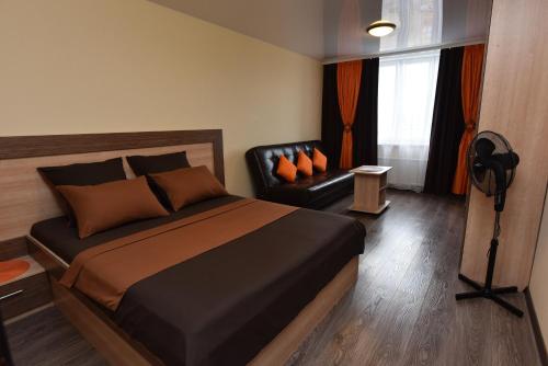 エカテリンブルクにあるApartments Аlexandria on Zavodskaya 75のベッドルーム1室(ベッド1台、黒い革張りの椅子付)