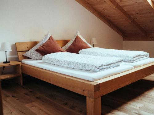 a wooden bed with pillows on it in a room at Eberlhof in Schechen