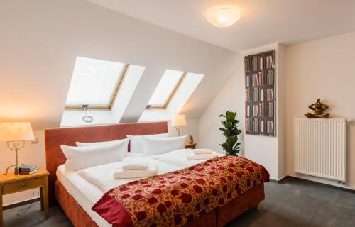 a bedroom with a large bed with white pillows at Apparthotel Bad Schandau by STEIGER Hotels in Bad Schandau
