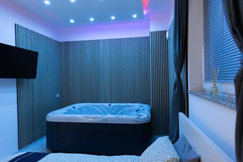 a bathroom with a blue tub in a room at Luxury Apartment Brendi in Log pri Brezovici