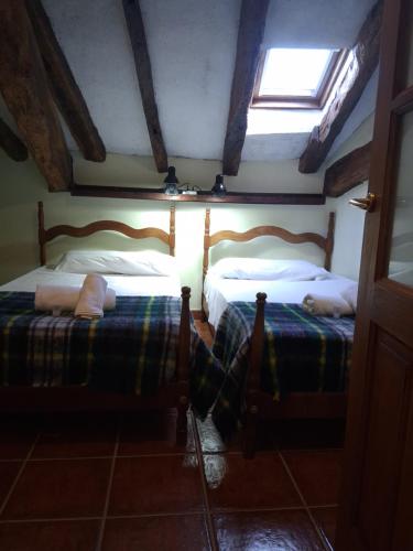 two beds in a room with a window at R2R - Ático con encanto Colindres - C08A01 in Colindres