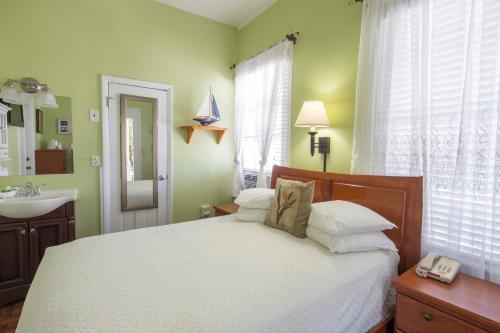 a bedroom with a bed with a sink and a mirror at The Palms Hotel in Key West