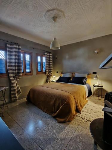a bedroom with a large bed in a room with windows at L'îlot in Sidi Ifni