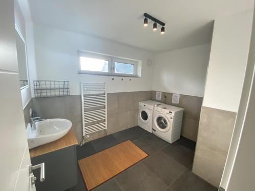 een badkamer met een wasmachine en een wastafel bij Altona365 - ApartE in Rellingen