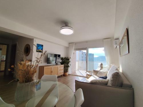 Una sala de estar con un sofá y una mesa de cristal. en Isla de los Pensamientos, en Faro de Cullera