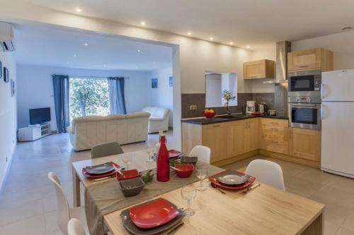 una cucina e un soggiorno con tavolo e sedie di Domaine Ghjulia - Casa Nebbiu a Patrimonio