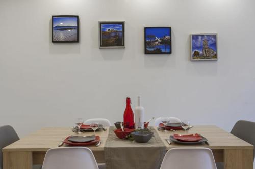 tavolo da pranzo con 4 immagini sul muro di Domaine Ghjulia - Casa Nebbiu a Patrimonio