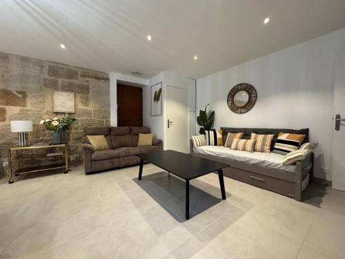 ein Wohnzimmer mit Sofa und Tisch in der Unterkunft Le Kandinsky, moderne et spacieux in La Celle-sous-Gouzon