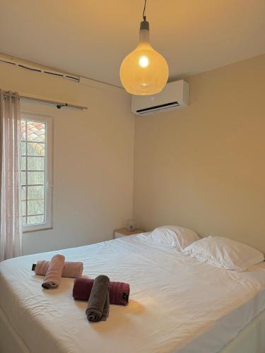 une chambre avec un grand lit blanc avec deux serviettes dessus dans l'établissement Le Borie climatisé, à Arles