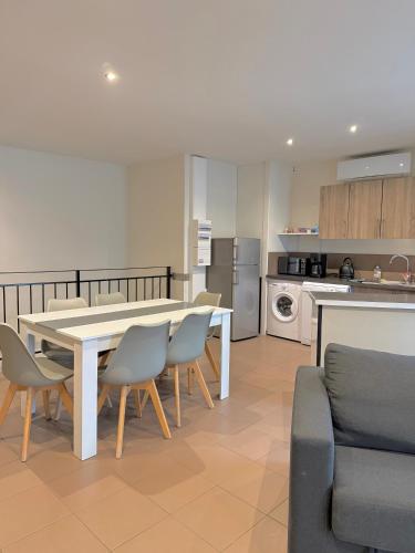 une cuisine et une salle à manger avec une table et des chaises dans l'établissement Le Borie climatisé, à Arles