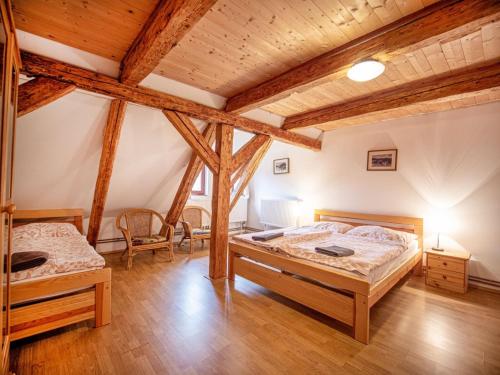 two beds in a room with wooden beams at Nová Hájovna in Říčky