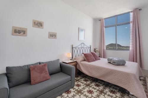 un soggiorno con divano, letto e finestra di Gar House a Caleta de Interián